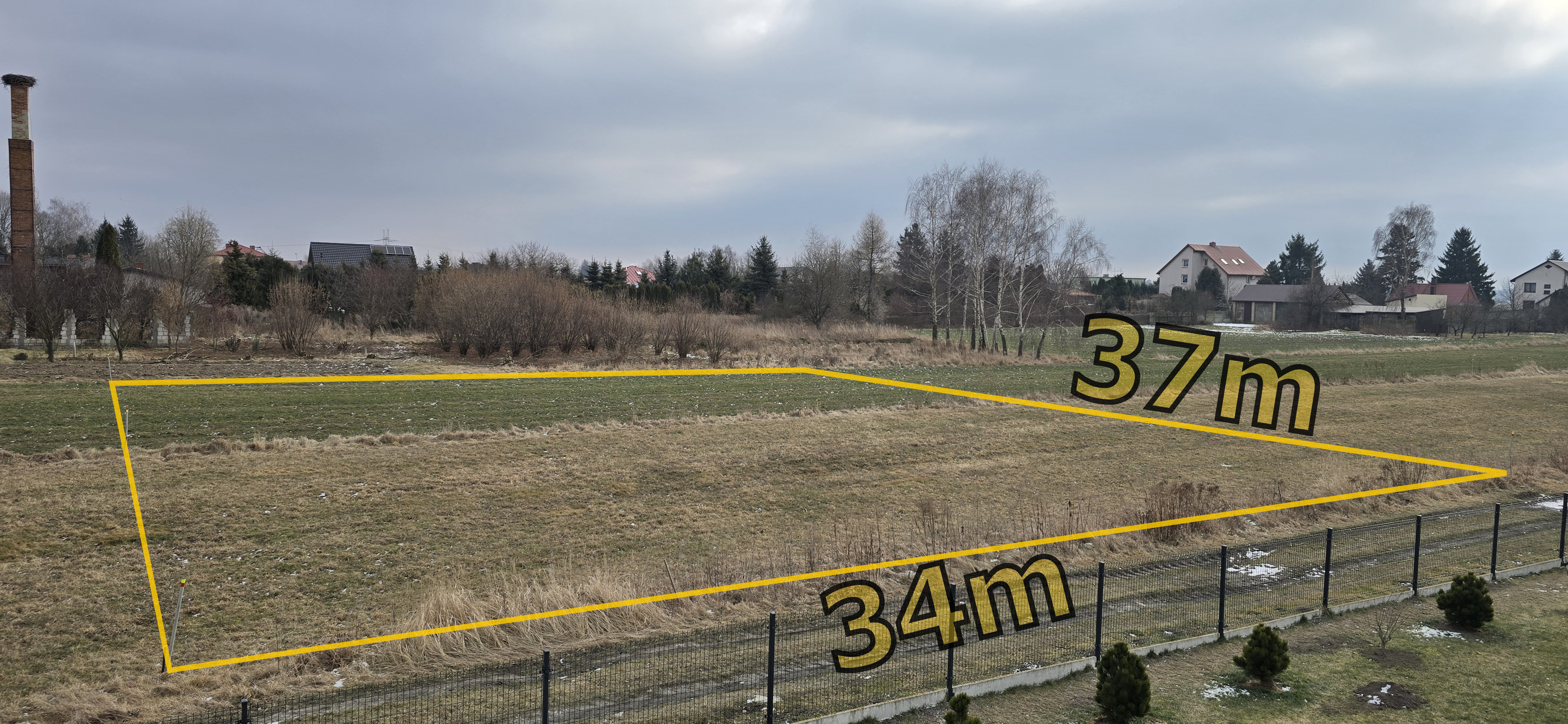 Działka budowlana przy drodze żwirowo-gruntowej, widziana z balkonu sąsiedniego domu. Wymiary 34x37m, powierzchni 1249m².