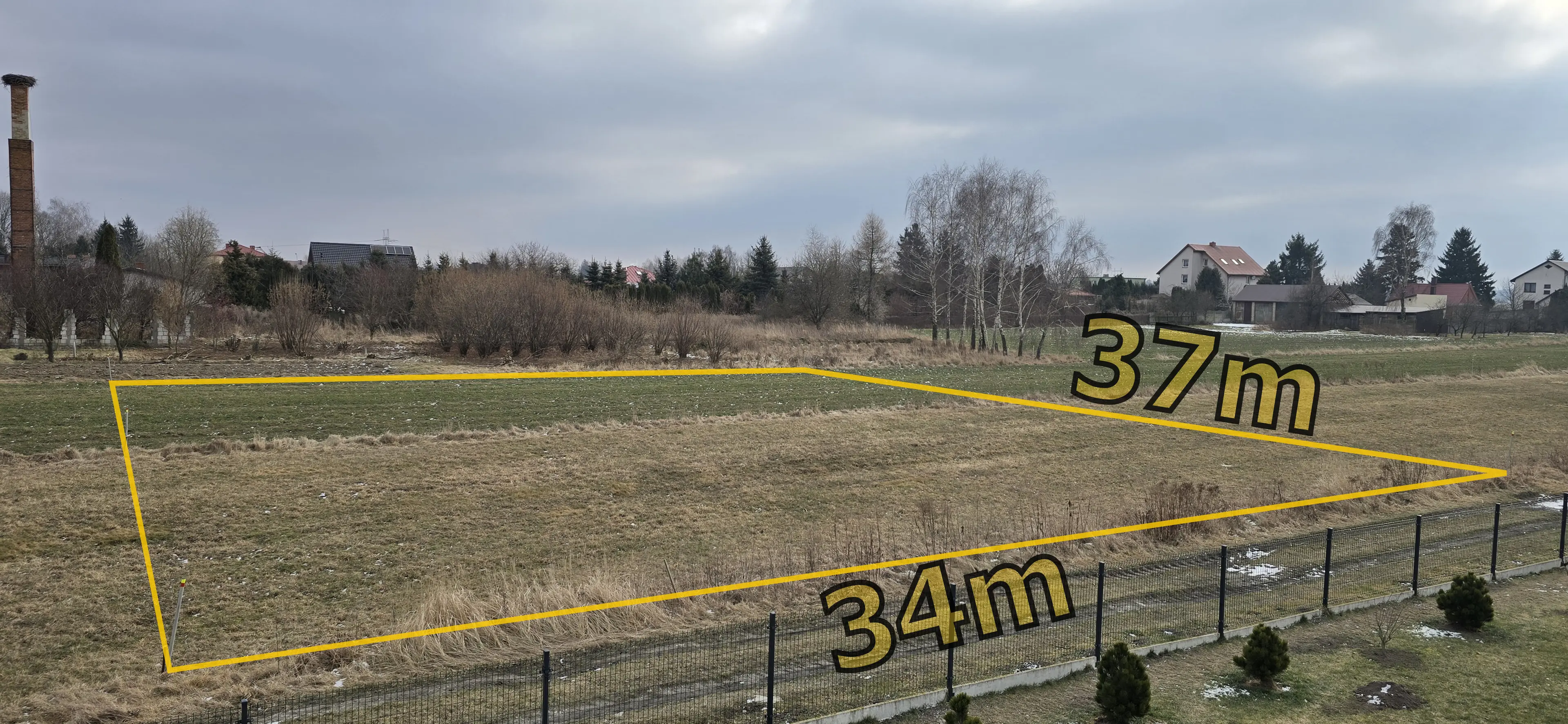 Działka budowlana przy drodze żwirowo-gruntowej, widziana z balkonu sąsiedniego domu. Wymiary 34x37m, powierzchni 1249m².