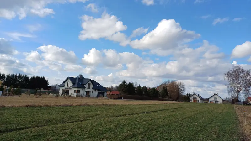 Działka 249/2: Widok z południowo wschodniego rogu działki w stronę północno zachodnią. W tle sąsiedni dom przy drodze wewnętrznej.